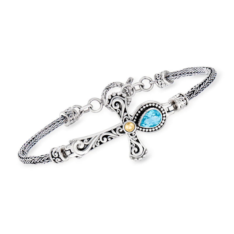 Sterling silver cross bracelet with blue oval gemstone and braided rope links.