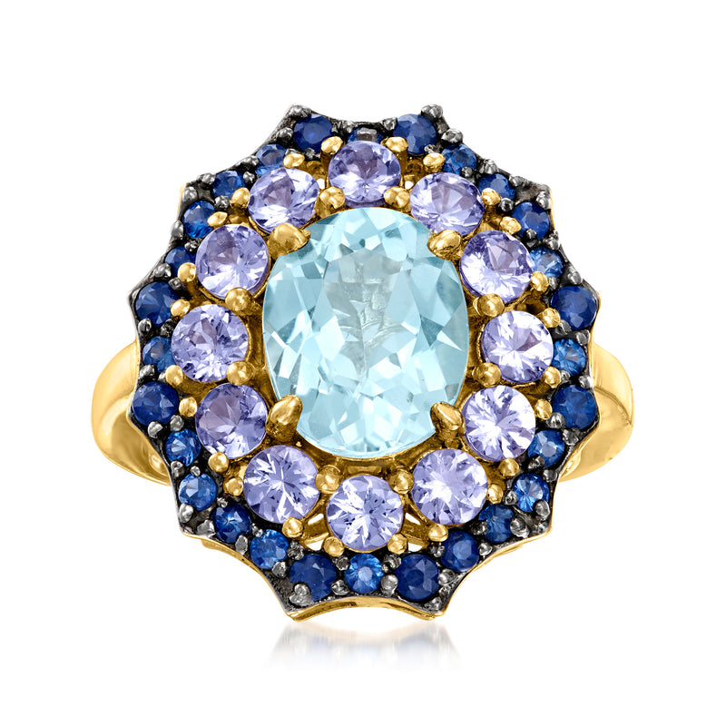Sky blue topaz ring with oval center stone, purple and blue gemstone halo, gold setting