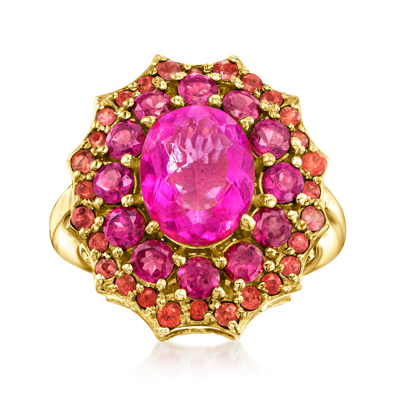 Gold-tone ring with oval pink gemstone center, surrounded by pink stones and scalloped halo