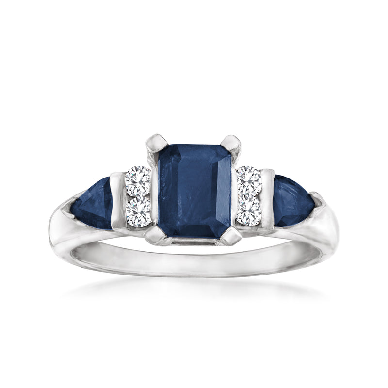 White gold ring with dark blue sapphire center and diamond side stones, prong set