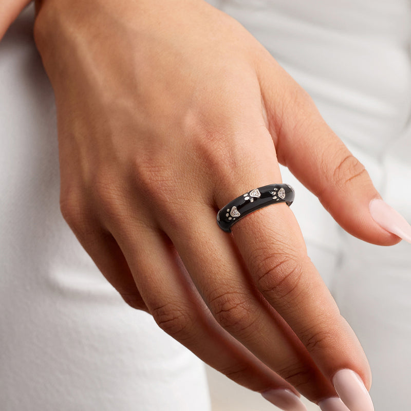 Black enamel paw print ring with CZs on sterling silver band, worn on finger