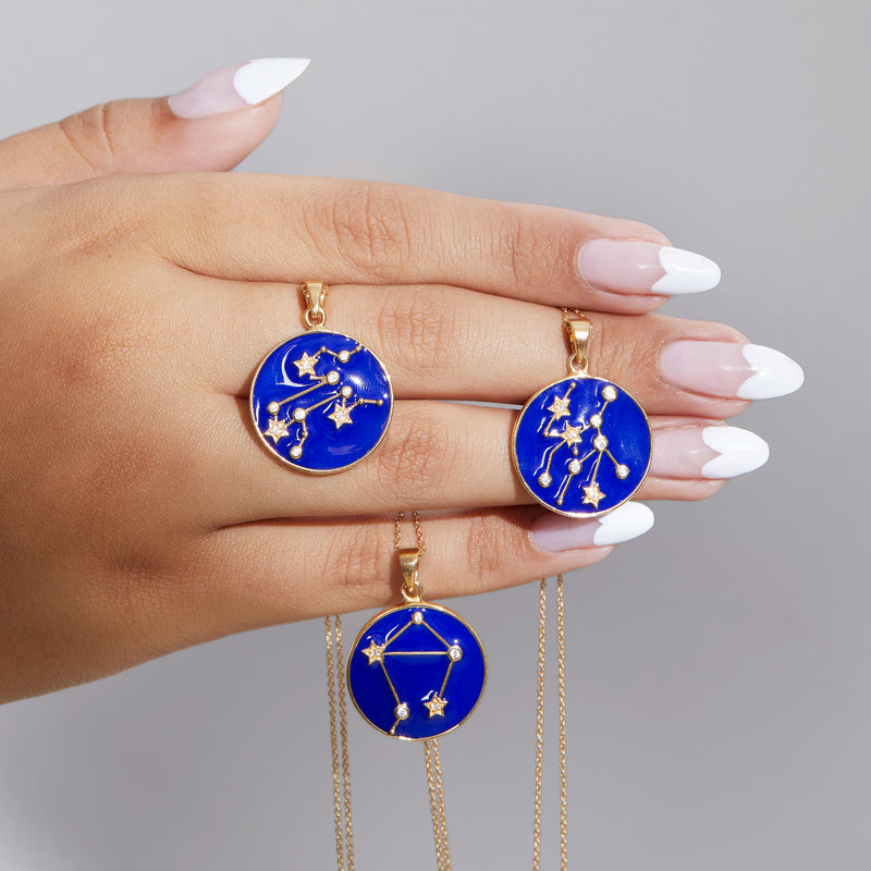 Gold-tone zodiac constellation pendant necklace with round blue enamel charm and zircon details