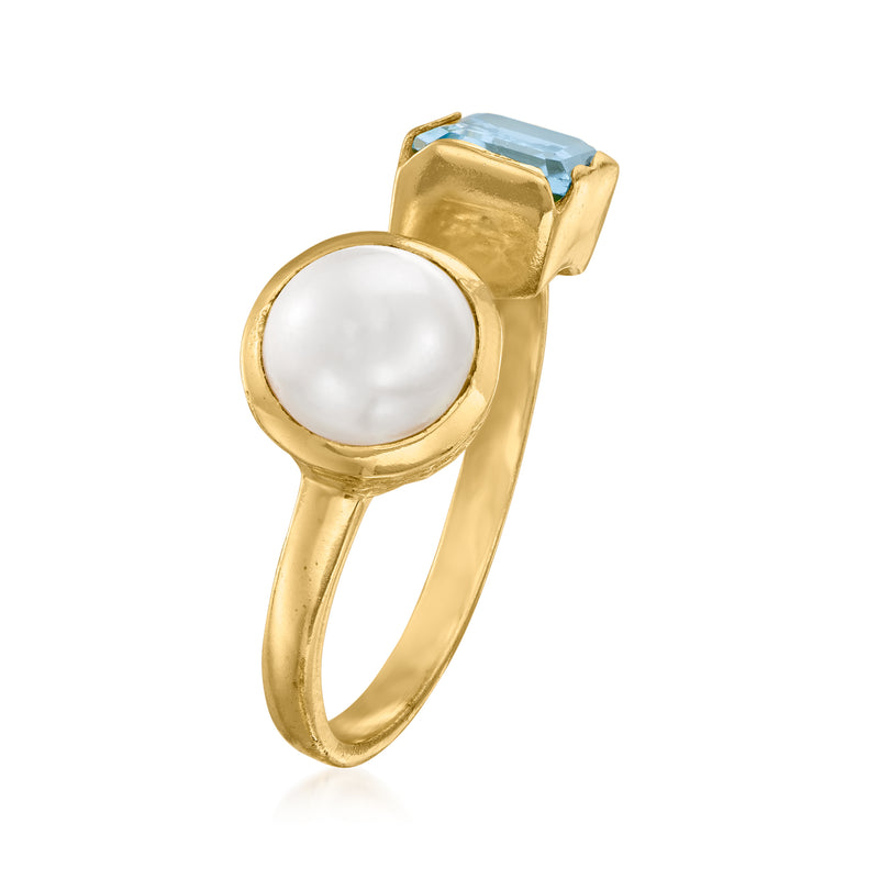 Gold ring view with round white pearl front and faceted sky-blue topaz side