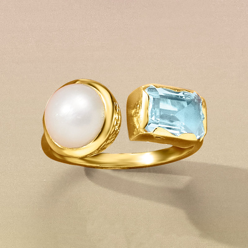 Gold toi et moi ring showing white pearl and square sky-blue topaz