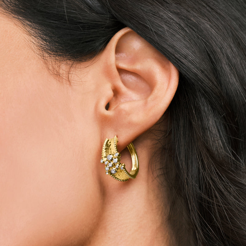 Diamond cluster hammered hoop earrings on ear, gold tone with round stones