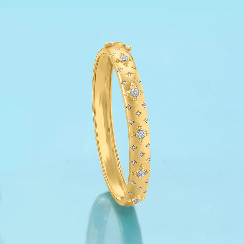 Gold bangle bracelet featuring round and star cluster stones along the side.