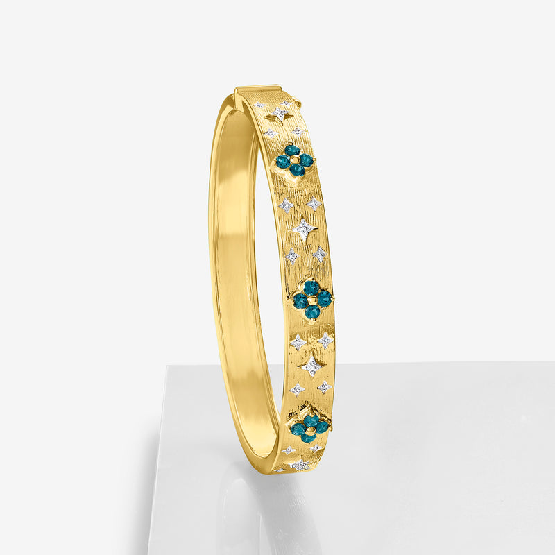 Gold bangle bracelet side view with blue topaz flowers and small diamond star shapes