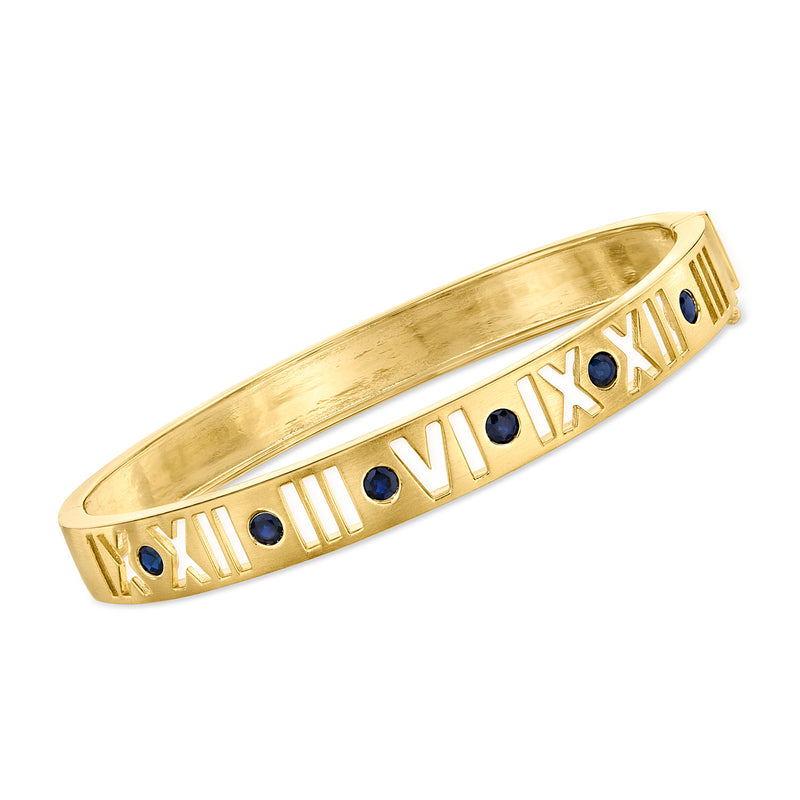 Gold bangle bracelet with Roman numeral inlay and blue sapphire stones
