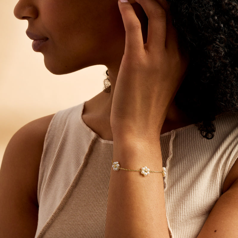 Cultured pearl flower station bracelet in 14kt yellow gold on wrist