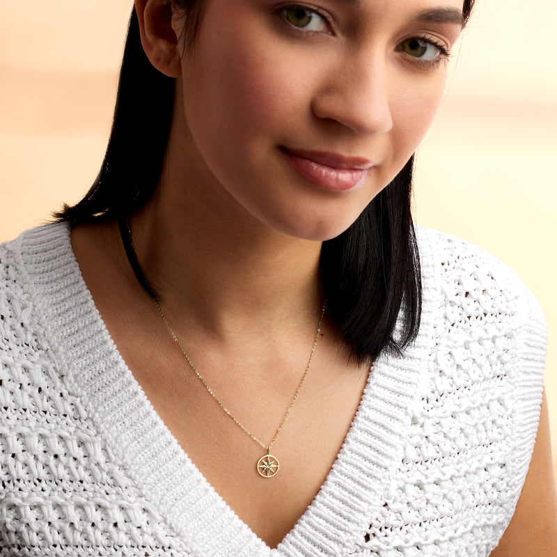 Yellow gold North Star pendant necklace on model with textured white sweater