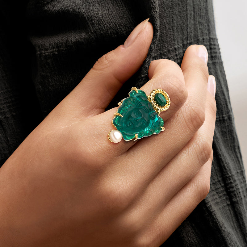 Green Medusa head ring on hand with round cultured pearl and gold accents