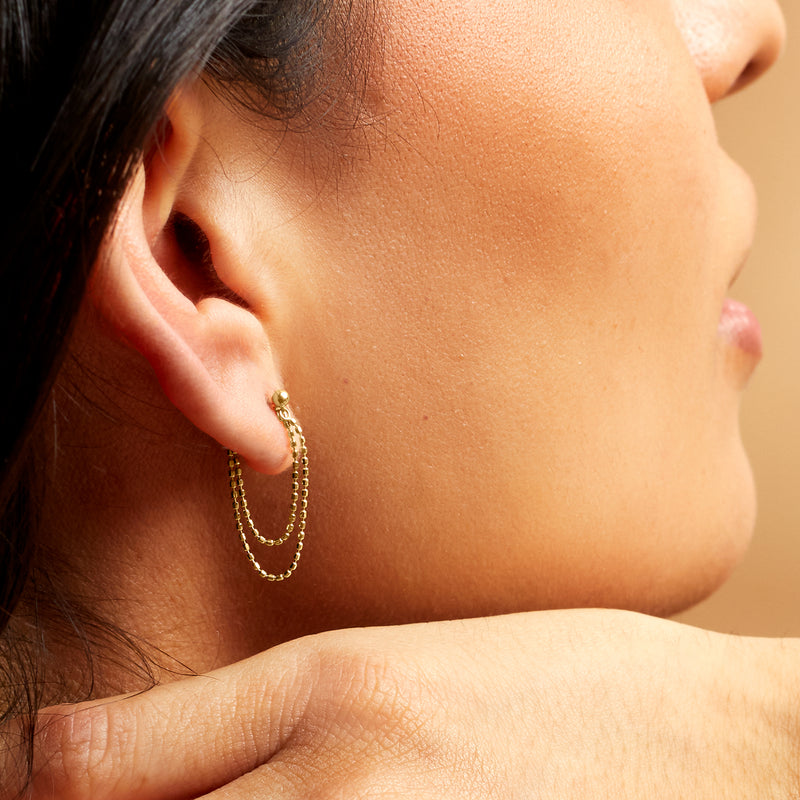 14kt yellow gold double-chain drop earrings on ear, side view with dangling chains