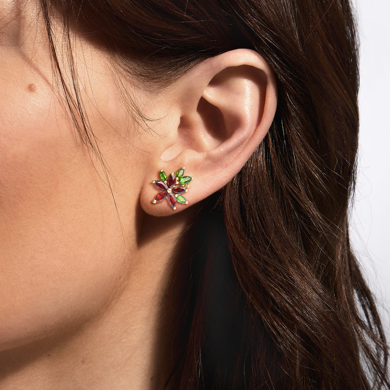 Multi-gem flower stud earring on ear, gold-tone with red and green stones