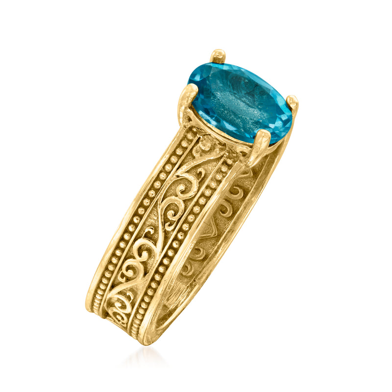 Gold over sterling scrollwork ring with teal-blue oval gemstone, angled view