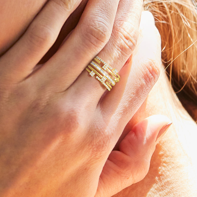 Diamond multi-row gold ring stacked on finger, baguette and round stones