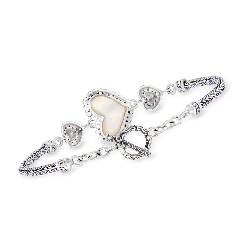 Sterling silver bracelet with three heart charms and mother-of-pearl heart centerpiece