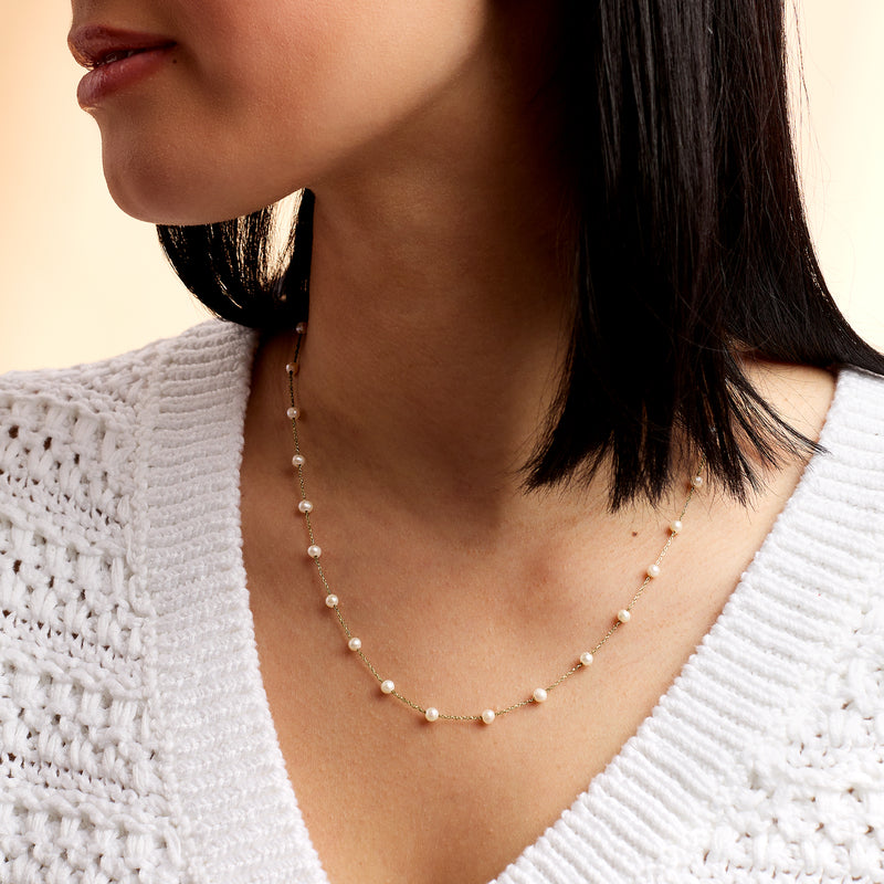 Cultured pearl station necklace with small round pearls on a thin 14kt yellow gold chain