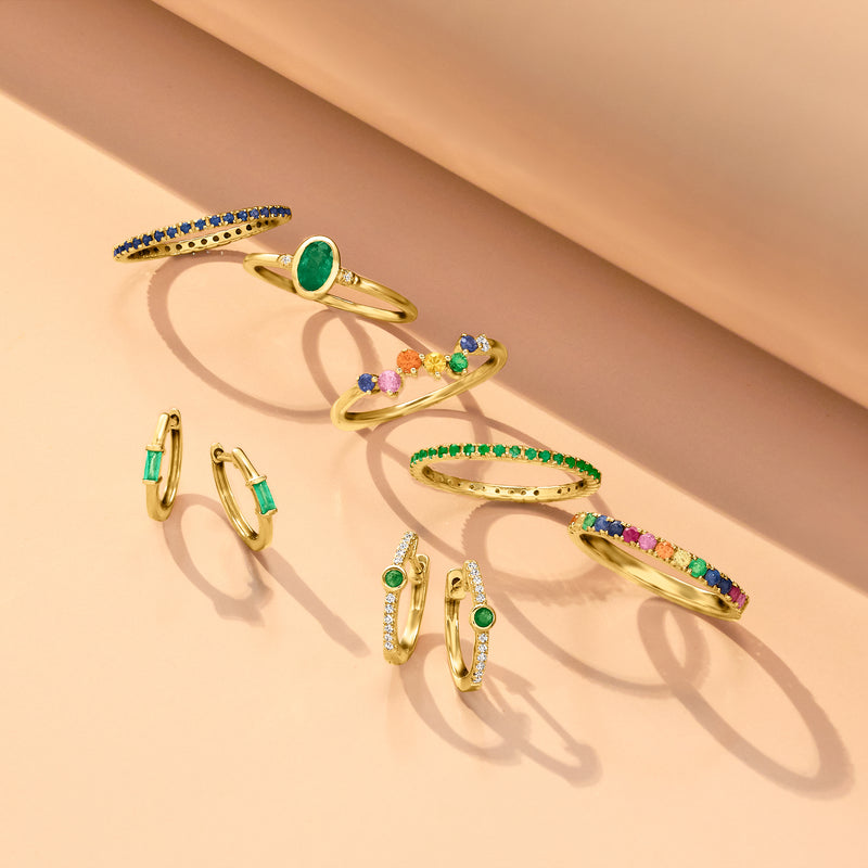 Set of yellow gold huggie hoop earrings with green emerald stone and sparkling accents