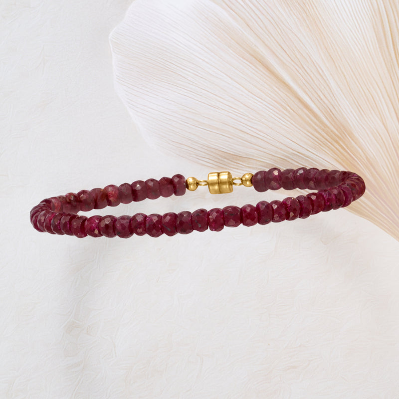 Ruby bead bracelet with gold magnetic clasp, laid flat