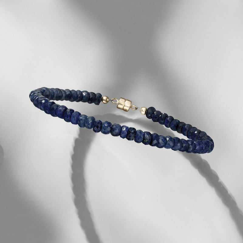 Sapphire blue bead bracelet with yellow gold magnetic clasp, side view