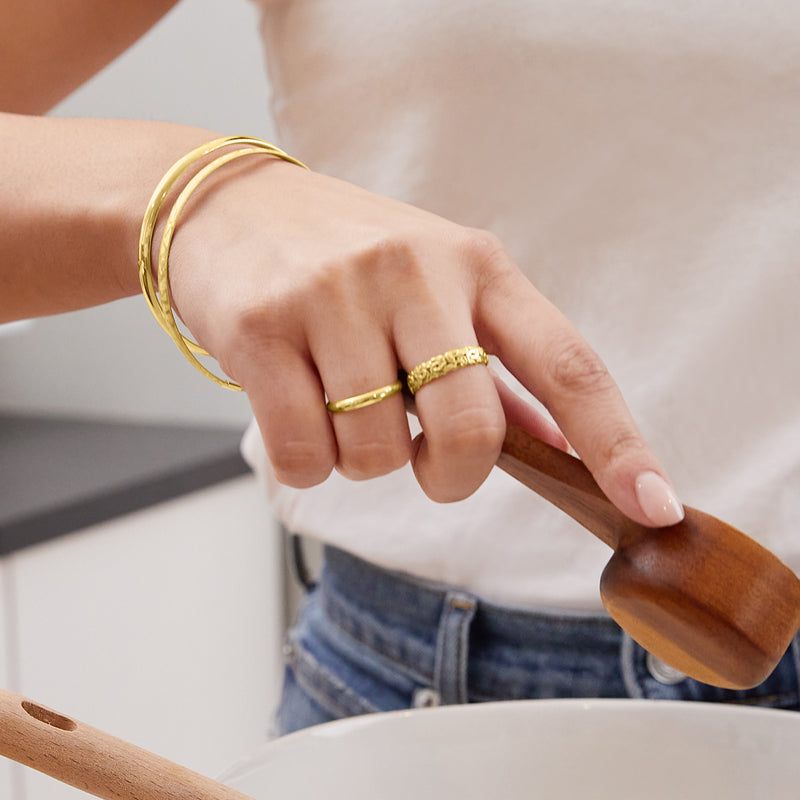 Yellow gold round bangle bracelet on wrist