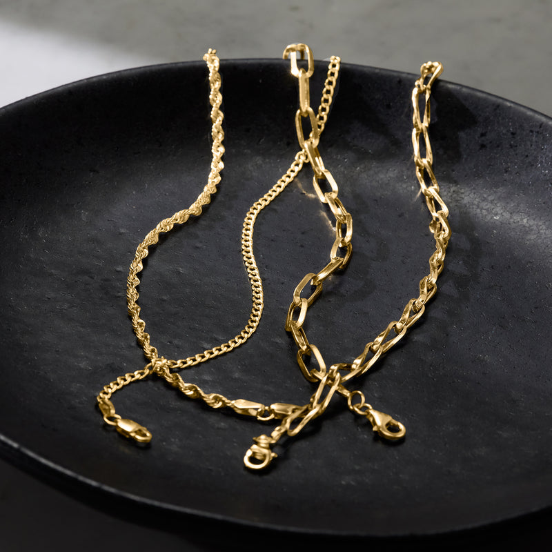 Yellow gold curb-link chain bracelet with lobster clasp, close-up of oval links