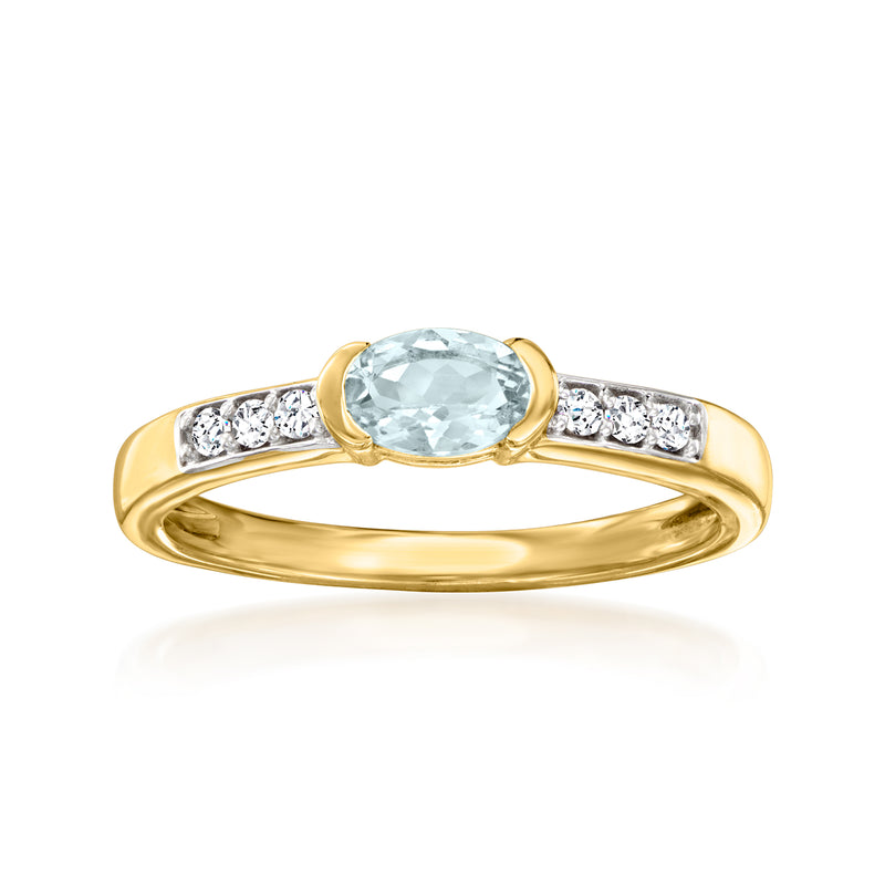 Gold ring with oval aquamarine center stone and white zircon side stones