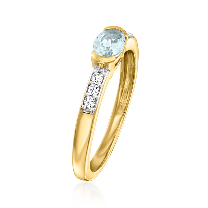 Gold ring angled view with oval aquamarine and rectangular white zircon accents