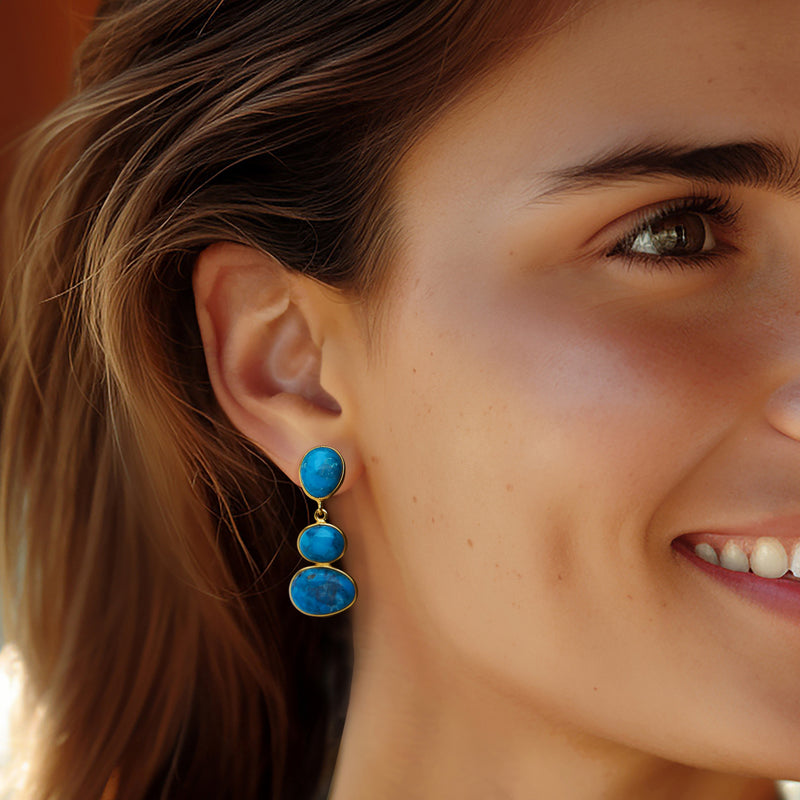 Turquoise drop earrings on model, three oval cabochons in gold over sterling