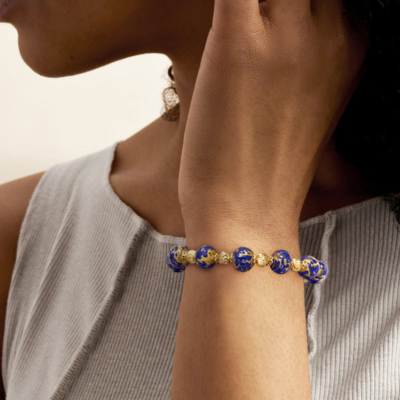Blue Murano glass bead bracelet on wrist, gold-tone links and round blue beads