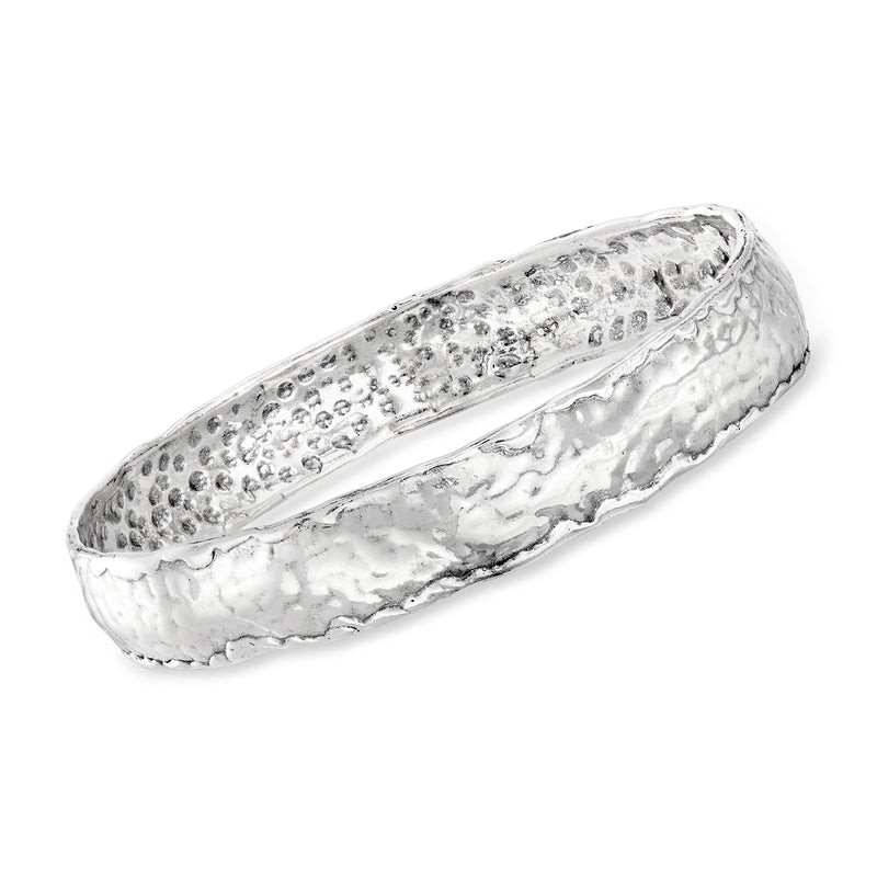 Hammered sterling silver bangle bracelet with textured surface and smooth inner band