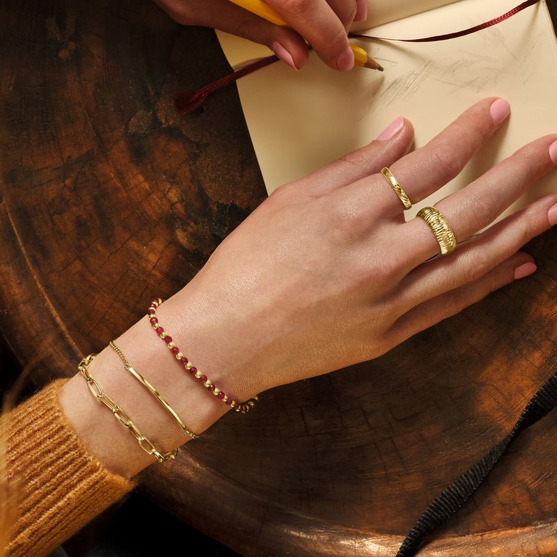 Yellow gold diamond-cut ring on finger, braided band with polished interior