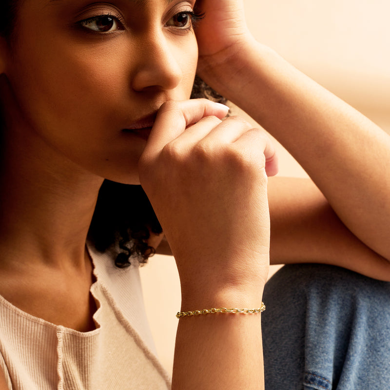 Worn 14kt yellow gold cable-chain bracelet with small oval links and clasp