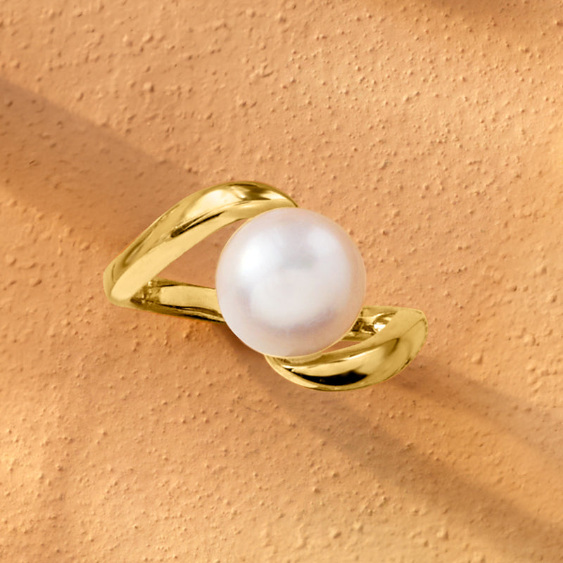 Twisted gold-tone ring with glossy white pearl, close-up