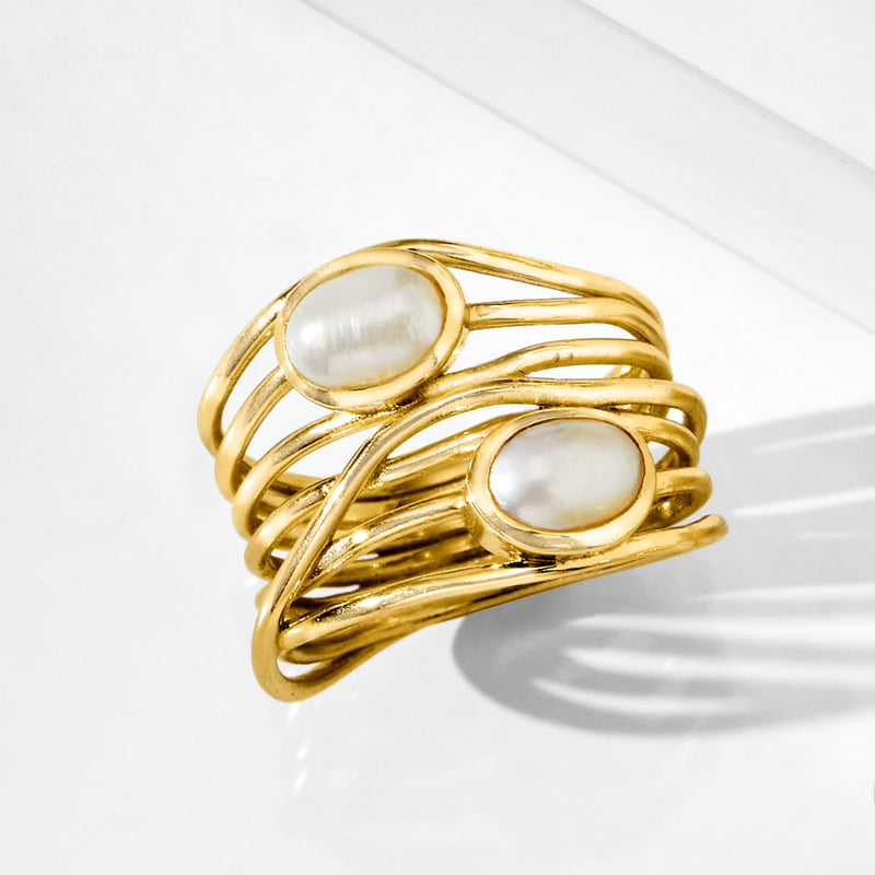 Gold-tone pearl highway ring with two visible oval cultured pearl settings