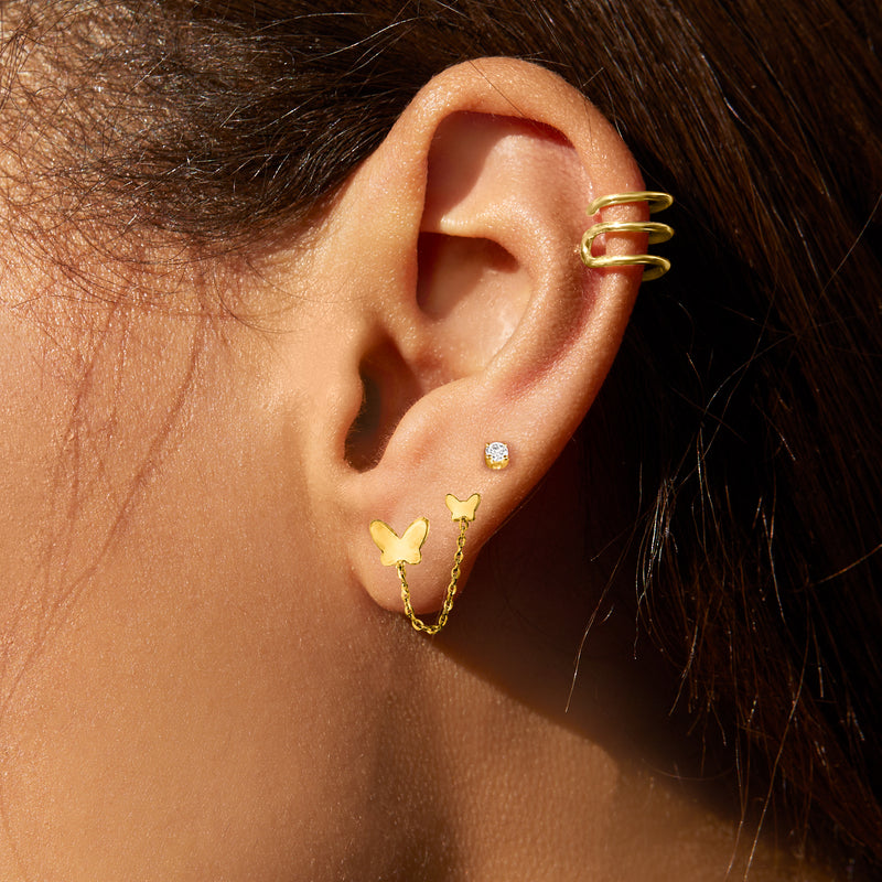 Multi-row yellow gold ear cuff with stacked curved bands on upper ear