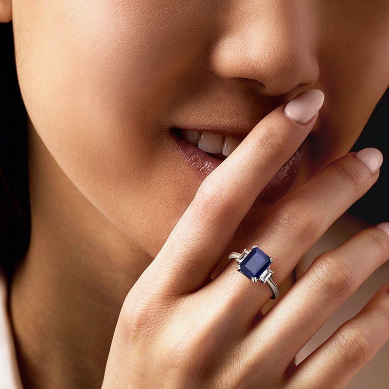 Sterling silver ring with square-cut blue sapphire on finger