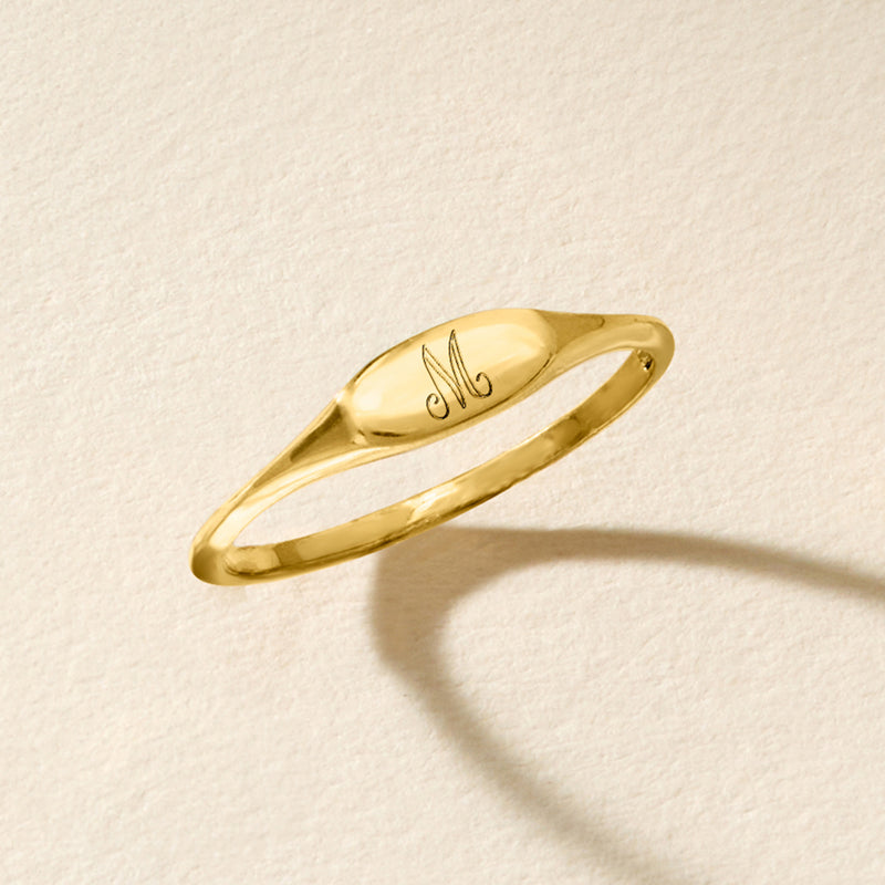 Personalized oval signet ring in 14kt yellow gold, side view with engraved M
