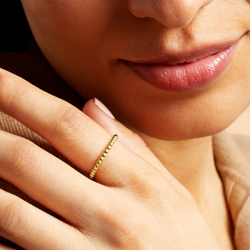 14kt yellow gold bead ring worn on finger with small rounded bead links