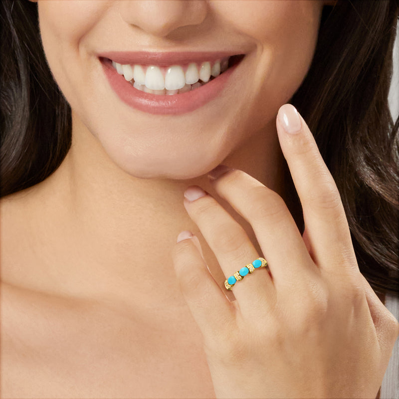 Turquoise gemstone ring with small diamond accents on finger, 10kt yellow gold