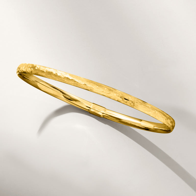 Yellow gold brushed bangle bracelet shown at an angle with hinged clasp