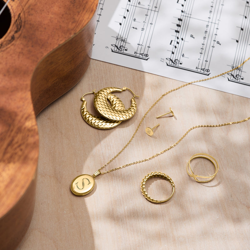 Yellow gold oval locket necklace with monogram charm and chain, with other jewelry