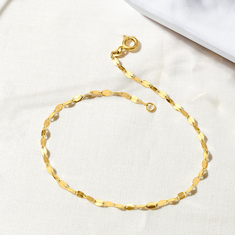 Close-up of yellow gold link bracelet with round clasp and small loop fastener