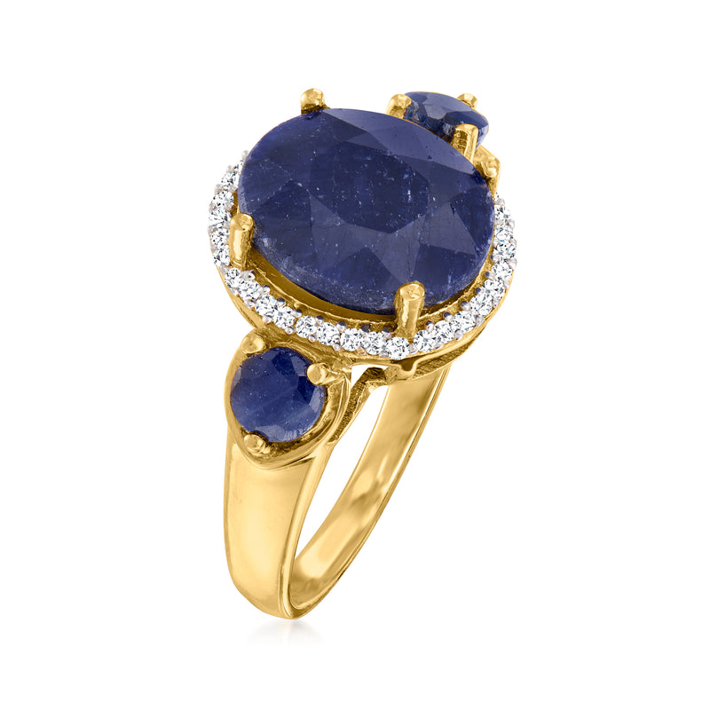 Gold ring with oval blue sapphire, diamond halo and side prong-set blue stones