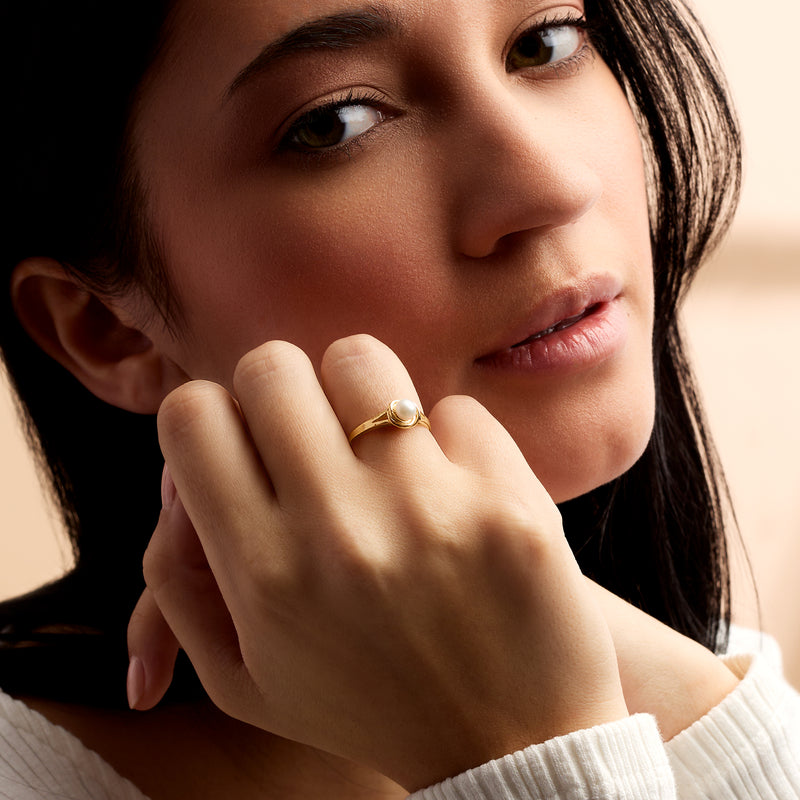 Cultured pearl ring on finger: 14kt yellow gold band with white round pearl