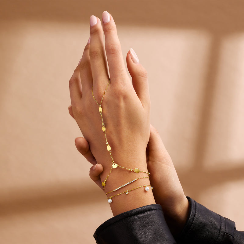 14kt yellow gold diamond bar bracelet on arm with dangling charm accents