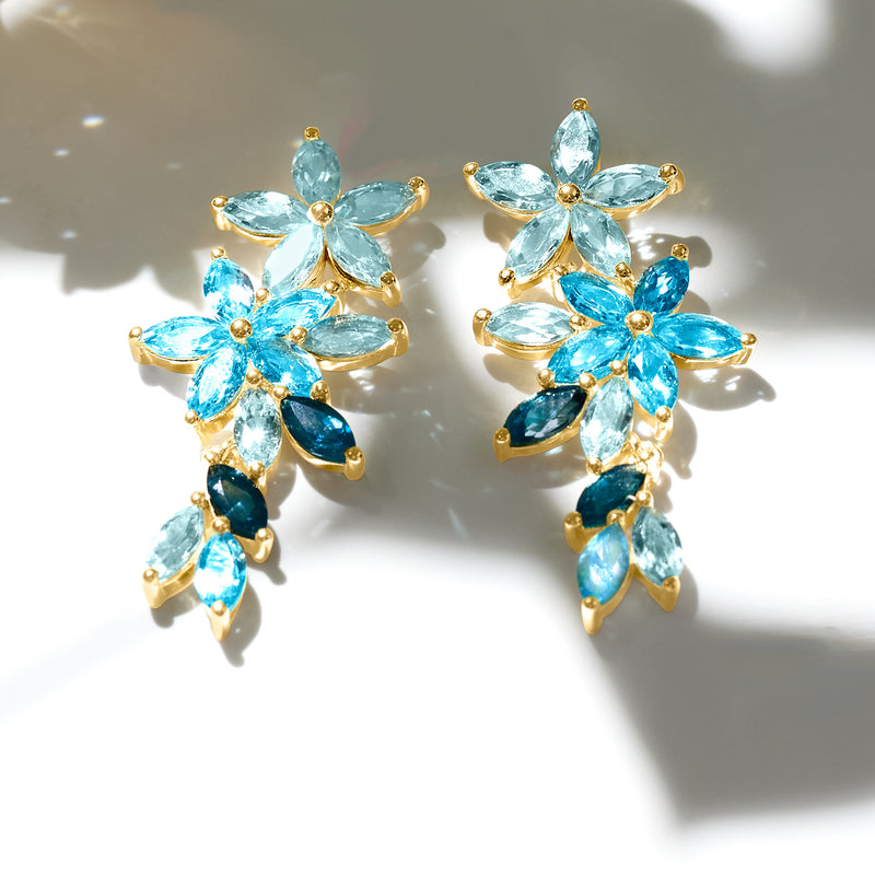 Gold-tone floral drop earrings with light blue and teal marquise gemstones, clustered