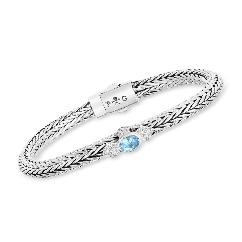 Sterling silver woven bracelet with blue oval center stone and prong-set halo