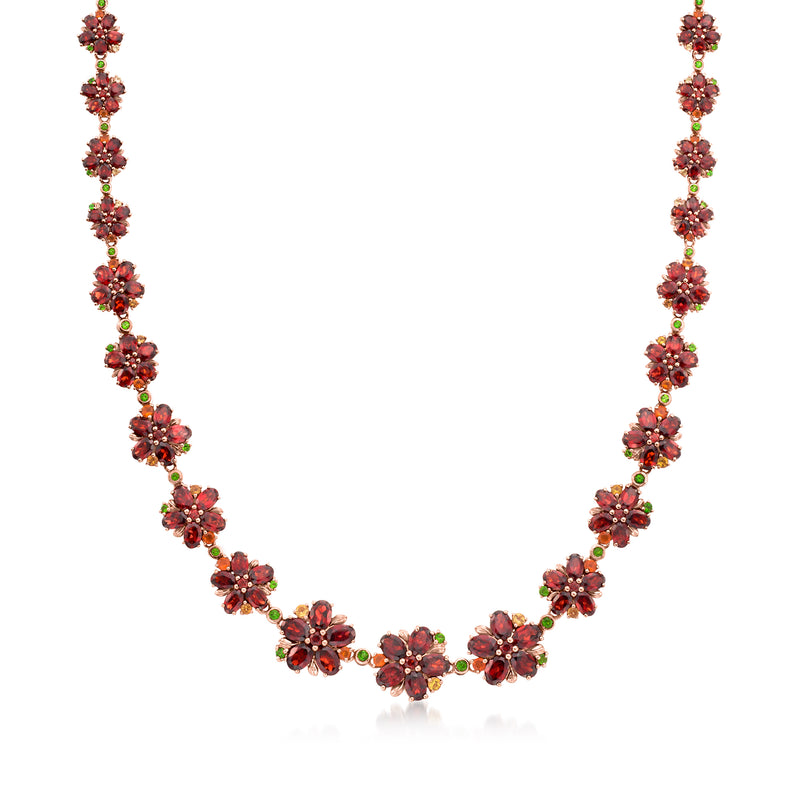 Floral multi-gemstone necklace with dark red and green teardrop accents on rose-gold tone chain