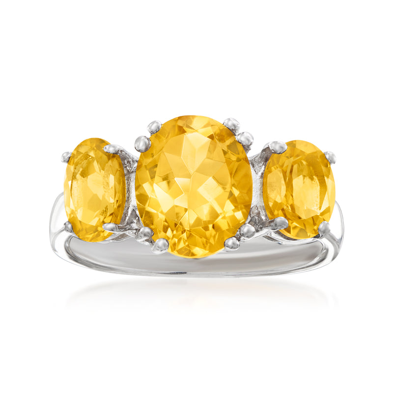 Sterling silver three-stone ring with three yellow citrine gemstones, oval settings.